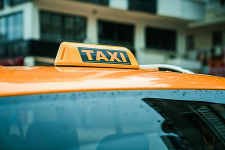 Close up yellow taxi sign on the roof of a car. Transport and tr