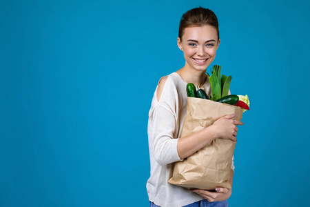 一个女人拿着装满食品的购物袋