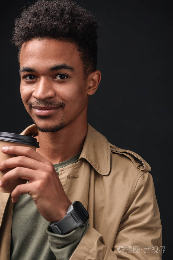 高兴的非裔美国人微笑着举着纸杯的照片