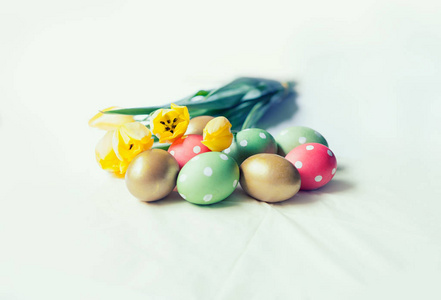 Tulips and decorated eggs on table 