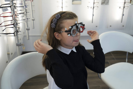 眼科医生用现代设备检查可爱的小女孩图片