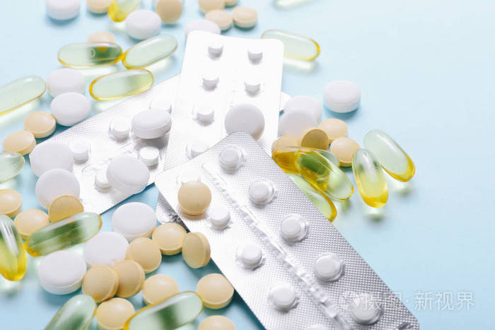 各种药物维生素药丸蓝色背景的药物