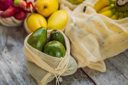 水果放在可重复使用的袋子里，放在时尚的木制厨房表面上。零浪费理念，无塑料概念。清洁饮食，健康饮食。夏季水果