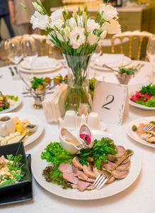 Table setting with meal and flowers on table, copy space. Place 