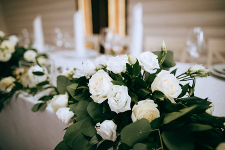 餐厅里漂亮的餐桌装饰有白玫瑰