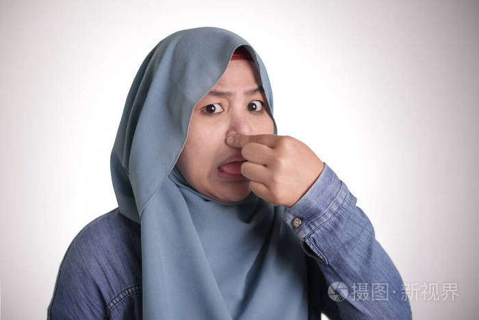 可爱的亚洲穆斯林女士闭上鼻子臭气熏天