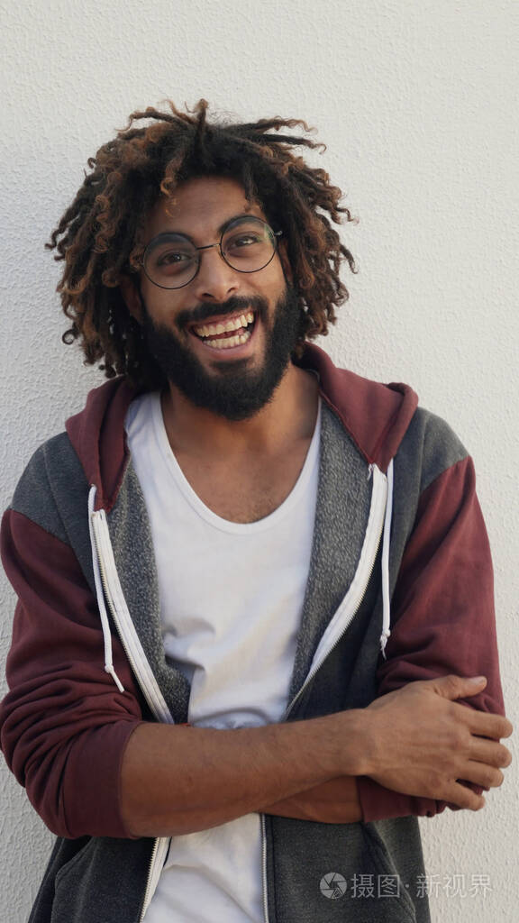 一个黑人对着白墙微笑的画像