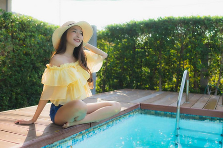 肖像年轻亚洲女人开心的微笑放松在户外游泳
