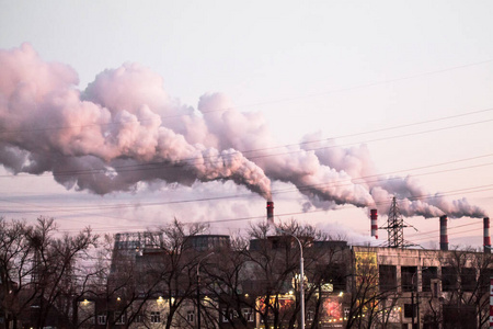 粉红色夕阳天空背景下浓烟造成空气污染的工业烟囱