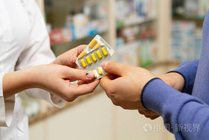 药剂师把药丸从手递给顾客