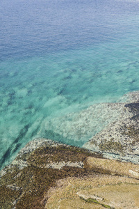 岩石和晶莹剔透的绿松石海为背景