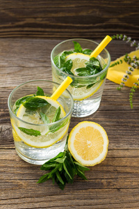 柠檬水或摩吉托鸡尾酒配柠檬和薄荷加冰块。用黄色餐巾装饰的夏日清凉饮料