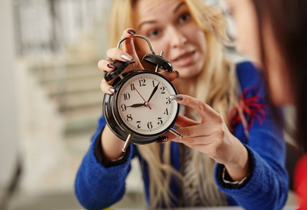 女商人在时钟上显示时间。关于时间框架的概念