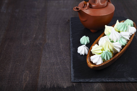 Meringue in a wooden bowl and kettle 
