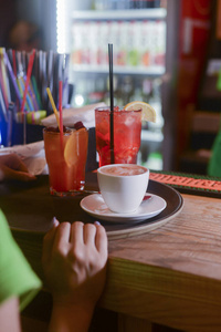 咖啡和两杯酒在酒吧的桌子上。在酒吧咖啡馆或餐馆工作的侍者和酒保。