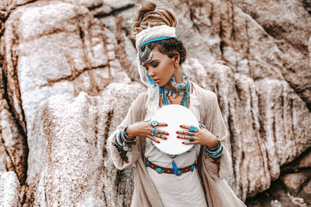 beautiful young woman in tribal costume with primal ornamet 