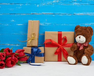 cute brown teddy bear sits on a blue wooden background, bouquet 