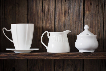 white kitchen dishware on old dark wooden background 