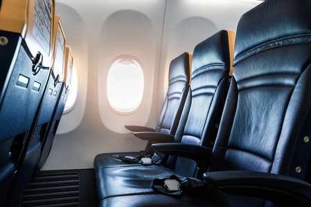 飞机内部带现代皮革座椅的飞机客舱。飞机座位和窗户。水平图像