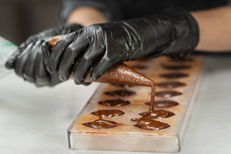 戴手套的糖果商把巧克力做成各种形状