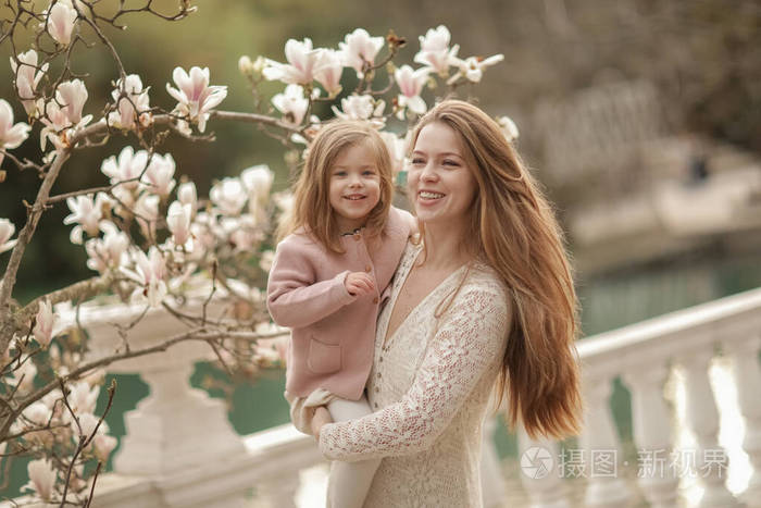 一个带着女儿在公园里的女人妈妈在散步时把爱女抱在胸前