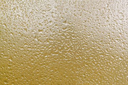 雨点落在黄色背景的窗户上照片