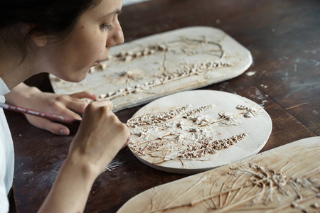 女刷从铸造粘土制品的模具上获得的浮雕图案