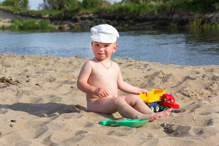 可爱的小男孩在热带海滩玩沙滩玩具