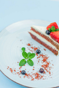 蓝色背景上有浆果和奶油的漂亮蛋糕。红蛋糕蛋糕蛋糕。