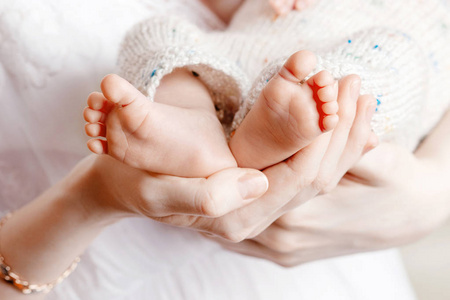 宝宝的脚在妈妈的手上。小宝宝的脚踩在女何身上