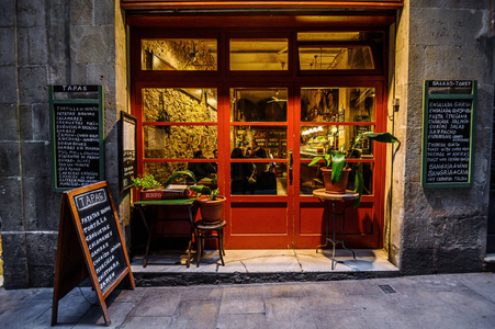 年夜画市中心一家挤满了人的餐厅的橱窗,夜幕降临.