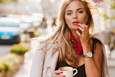 体贴的金发女子,青铜色皮肤,在咖啡馆享受自由时光.