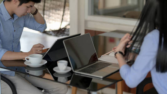 Cropped shot of businesspeople focusing on their work with lapto