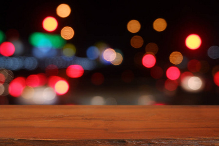 Empty wooden table in front of abstract blurred bokeh light of C