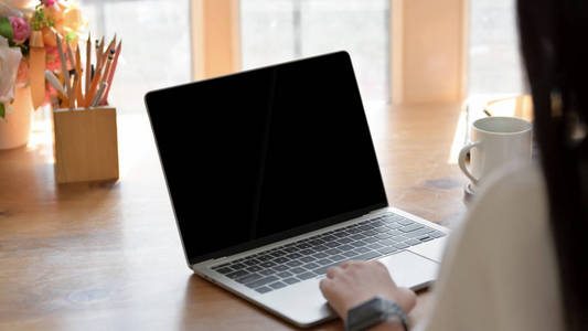 Closeup view of girl working on her project while typing on lap