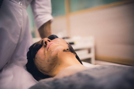 妇女黑面具戴黑面具的妇女在程序碳激光剥皮.照片