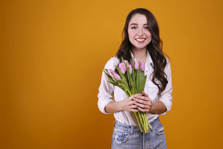 美丽的女性手持一束春天的鲜花庆祝国际妇女节。