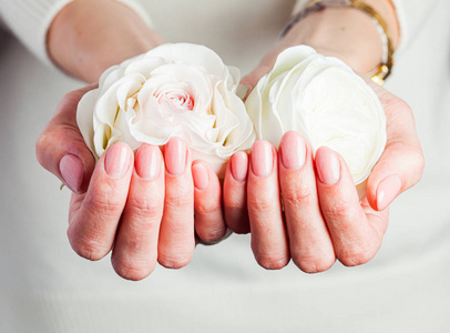 女性手护理和治疗概念。粉嫩修指甲，特写。