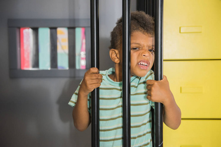 小男孩在游戏室坐牢.照片