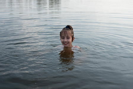 男生喜欢少女漫快乐美丽的小女孩在蓝色的水里游泳,露出水面微笑