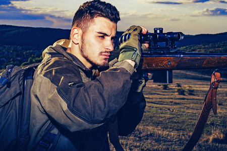 猎人拿着猎枪在打猎.在森林里非法捕猎偷猎者.猎枪.照片