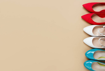 亮色高跟女鞋在纯色米色背景上.平铺俯视图复制空间文本.照片