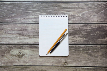 Notepad with a blank white sheet in a checker paper with ball pe