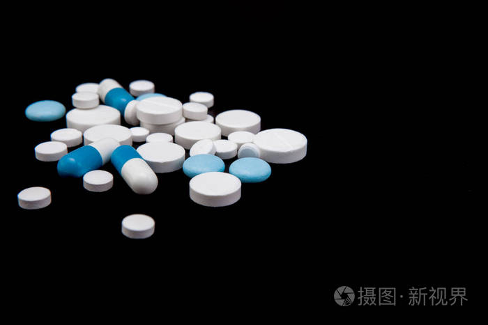 黑色背景的药丸和胶囊药物和膳食补充剂