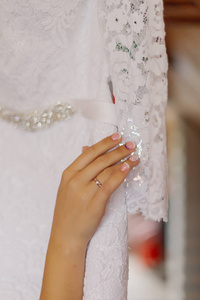 年轻的新娘手拿婚纱。