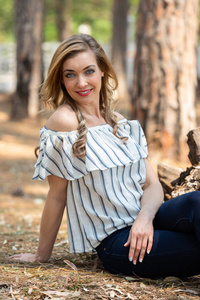 Portrait of a blonde woman with a striped blouse sitting on the 