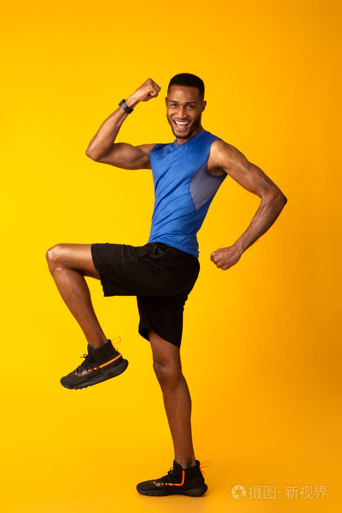 年轻的黑人运动员高举着膝盖走路