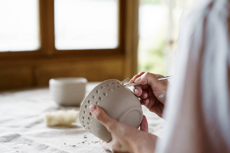 女性手拿碗，用来铸造粘土制品