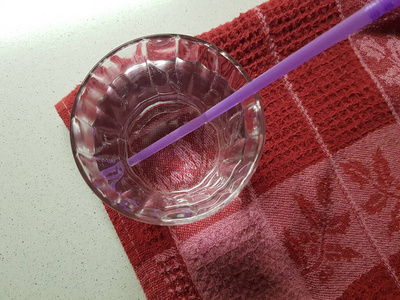 一整杯水和一条红色毛巾上的饮水管。