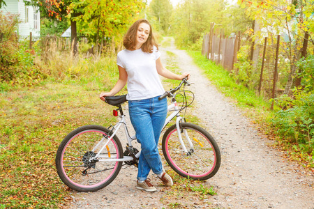 Young woman riding bicycle in summer city park outdoors. Active 